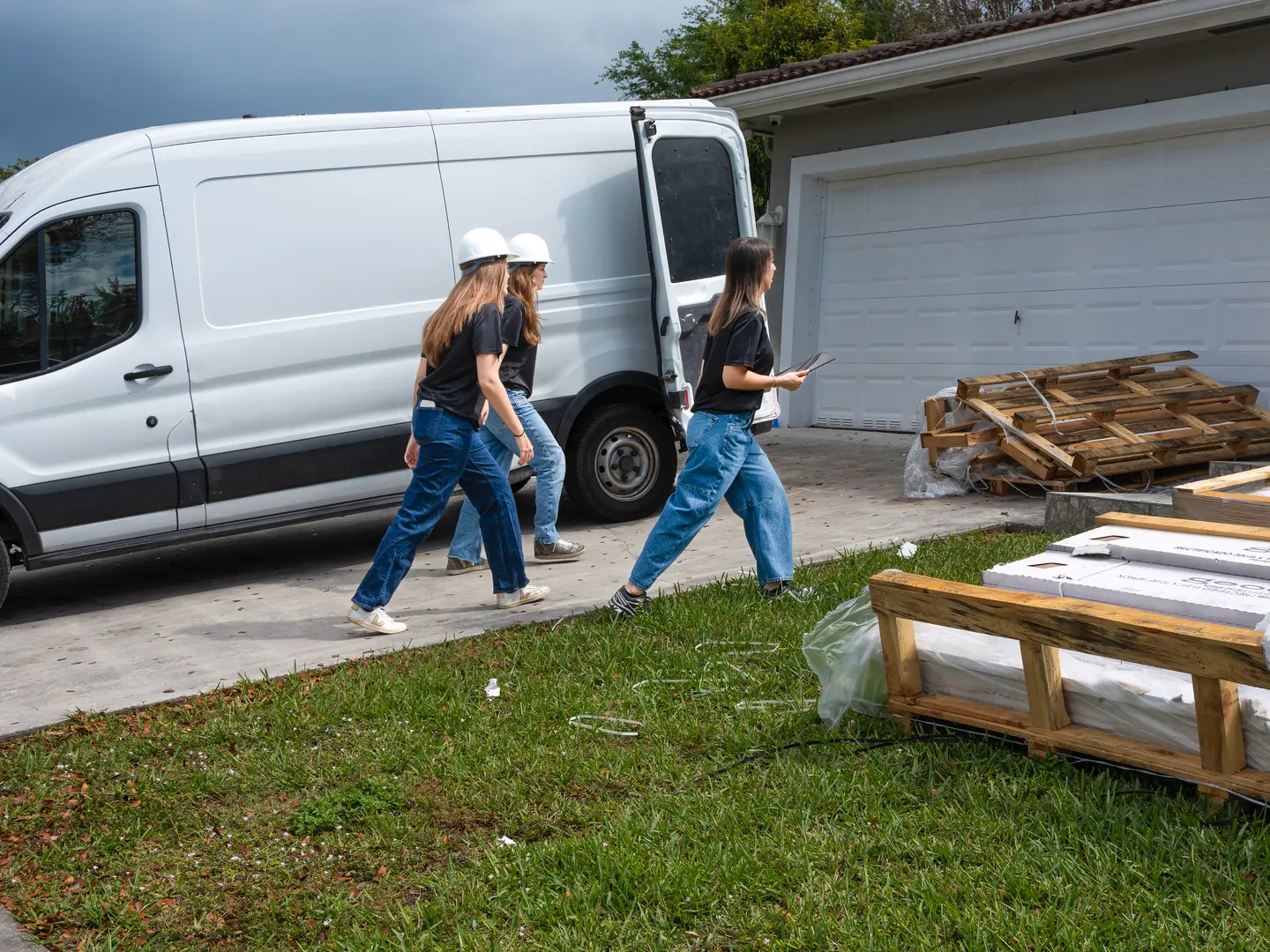 A Gaven Constructions van and crew arriving at a single-family South Florida house, with pallets of material waiting on the lawn