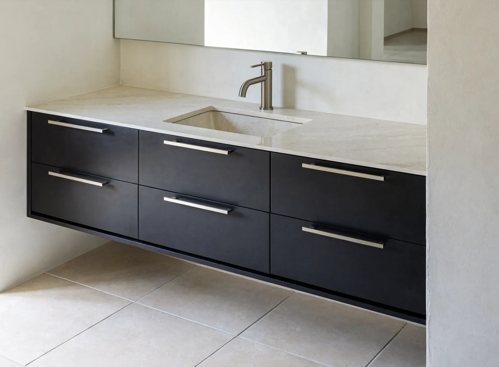 A finished bathroom vanity in a Davie house, new drawers under a stone top with an undermount sink, the tile floor clear at the toe kick
