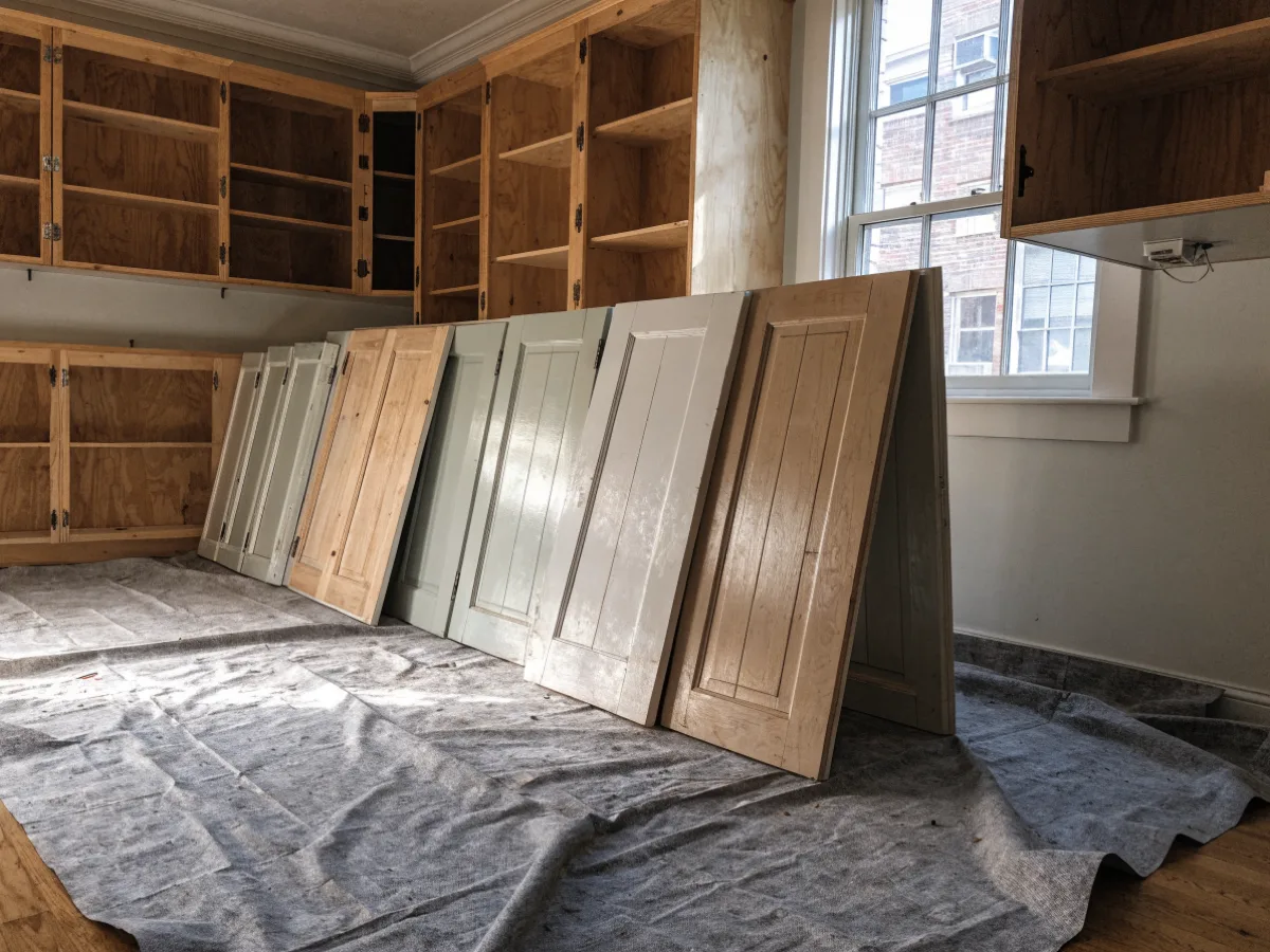A kitchen near Bergeron Rodeo Grounds in Davie with every cabinet door taken off and stood in a row against the wall, the open boxes left in view