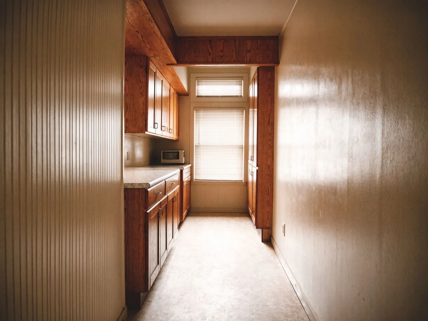 Cabinet maker in Davie, FL: a closed galley kitchen from the 1980s with its original cabinets and soffit
