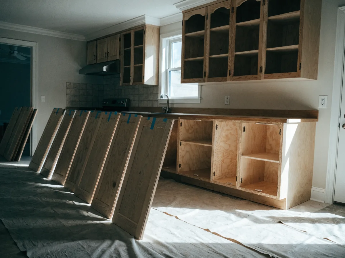 Every door taken off a long cabinet run in a Davie kitchen and stood against the wall numbered with tape, the boxes still mounted and open