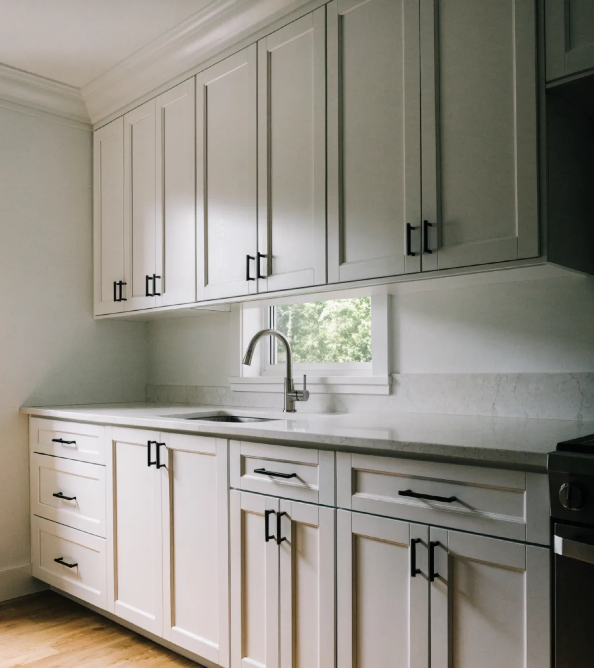 Cabinet maker near Western High School in Davie: a finished perimeter run in painted shaker with plywood boxes and pulls installed, in a high ceilinged kitchen