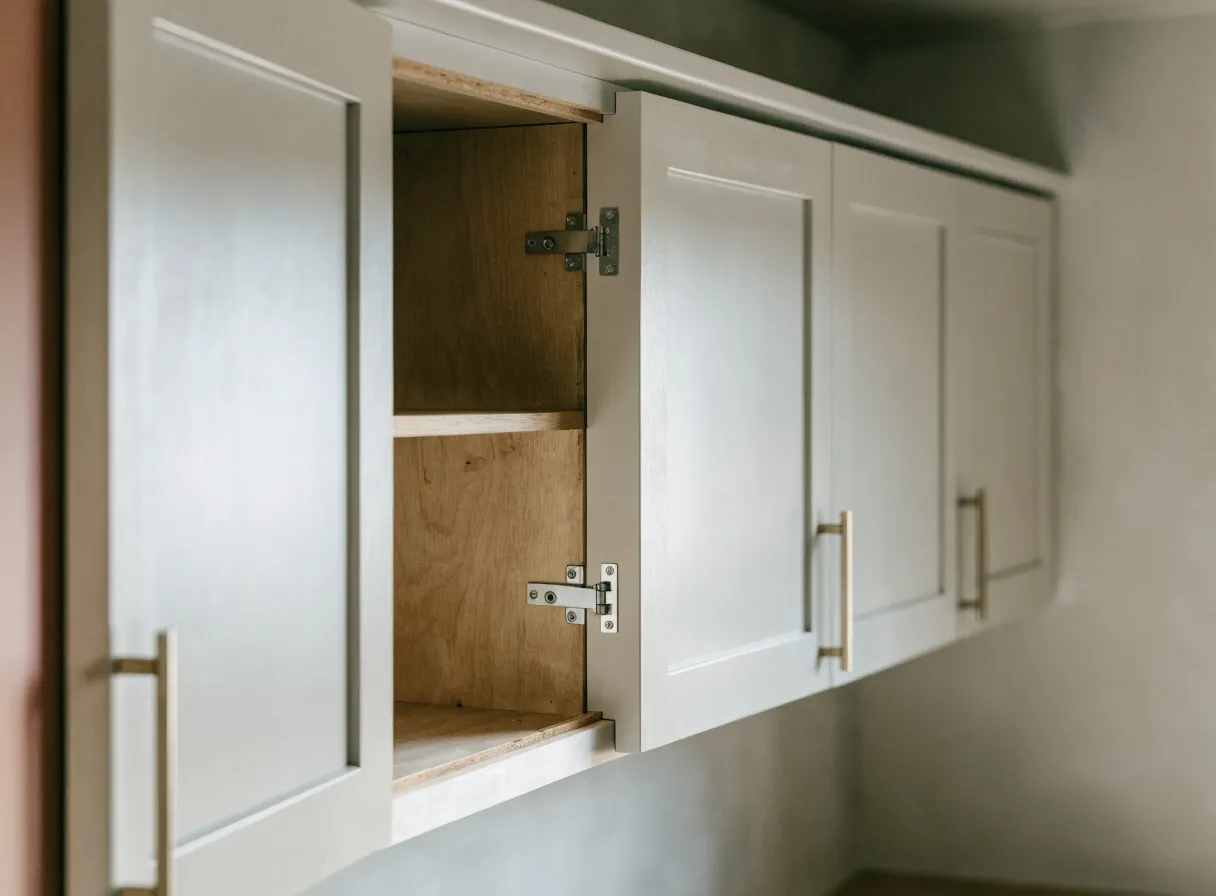 Cabinet refacing in Davie, FL: one wall cabinet door standing open, the new skin on the face frame around it and the original cabinet box and shelf behind