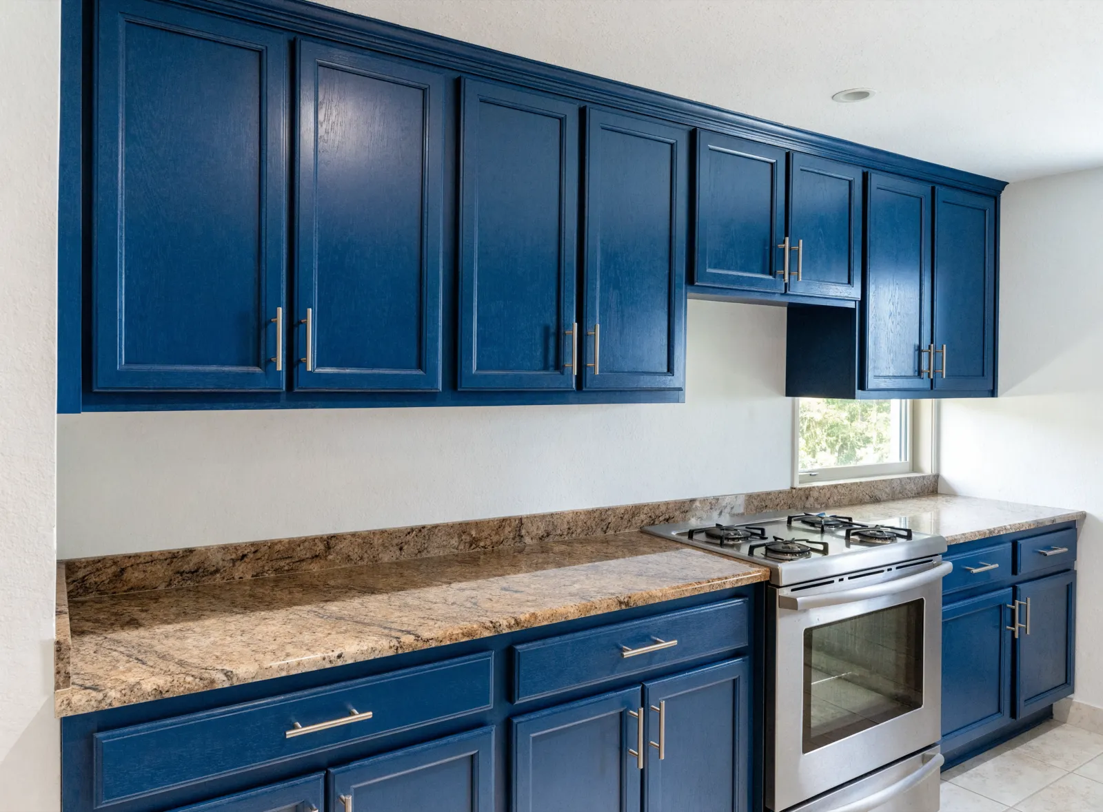 Refinished kitchen cabinets in Davie, FL painted navy under the speckled granite that was already there
