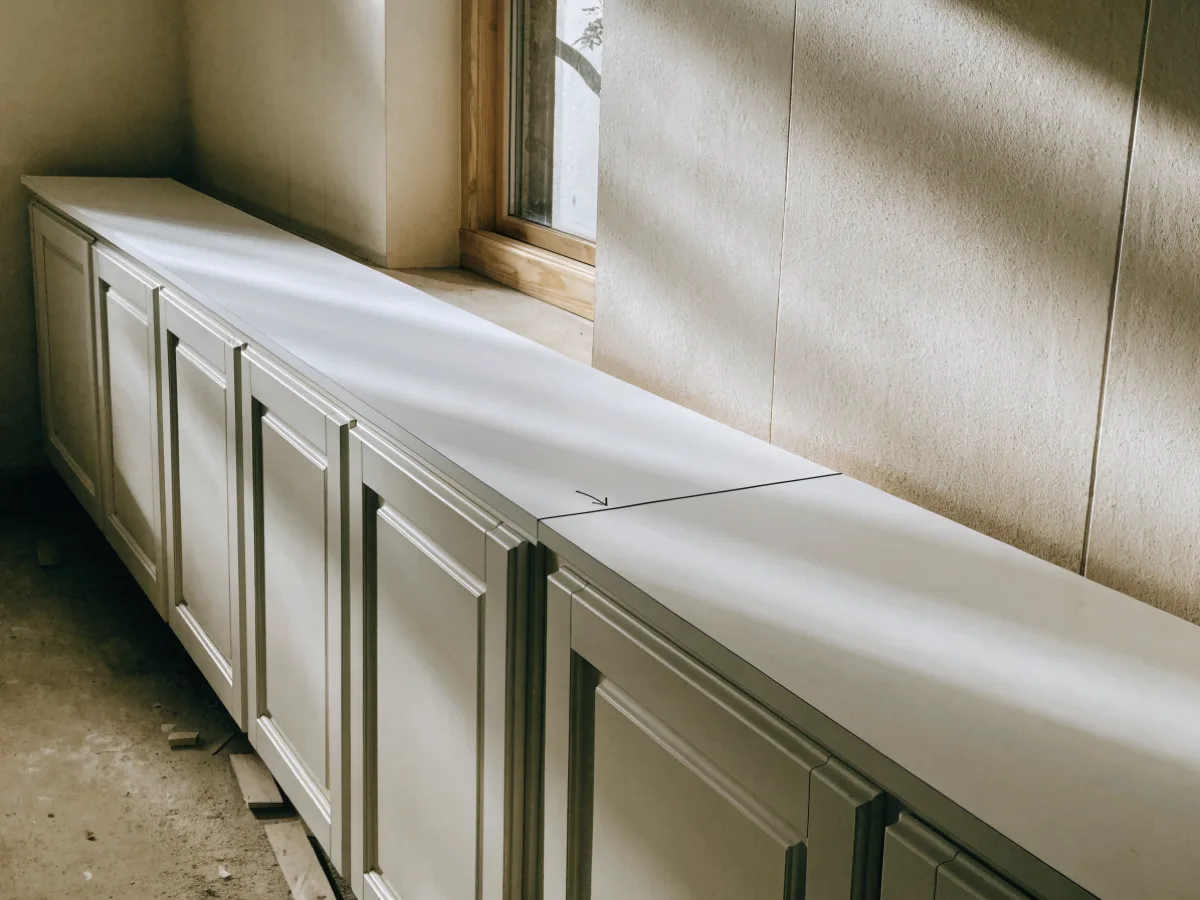 The seam position marked in pencil on a template laid over the counter run of a Davie kitchen, before the stone is cut