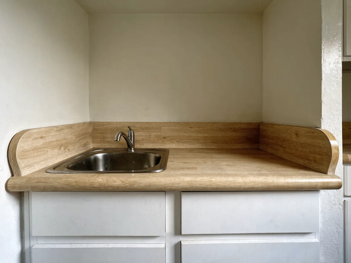 The original laminate counter in a Davie unit kitchen, a post formed edge, a drop in sink and a short run against the wall