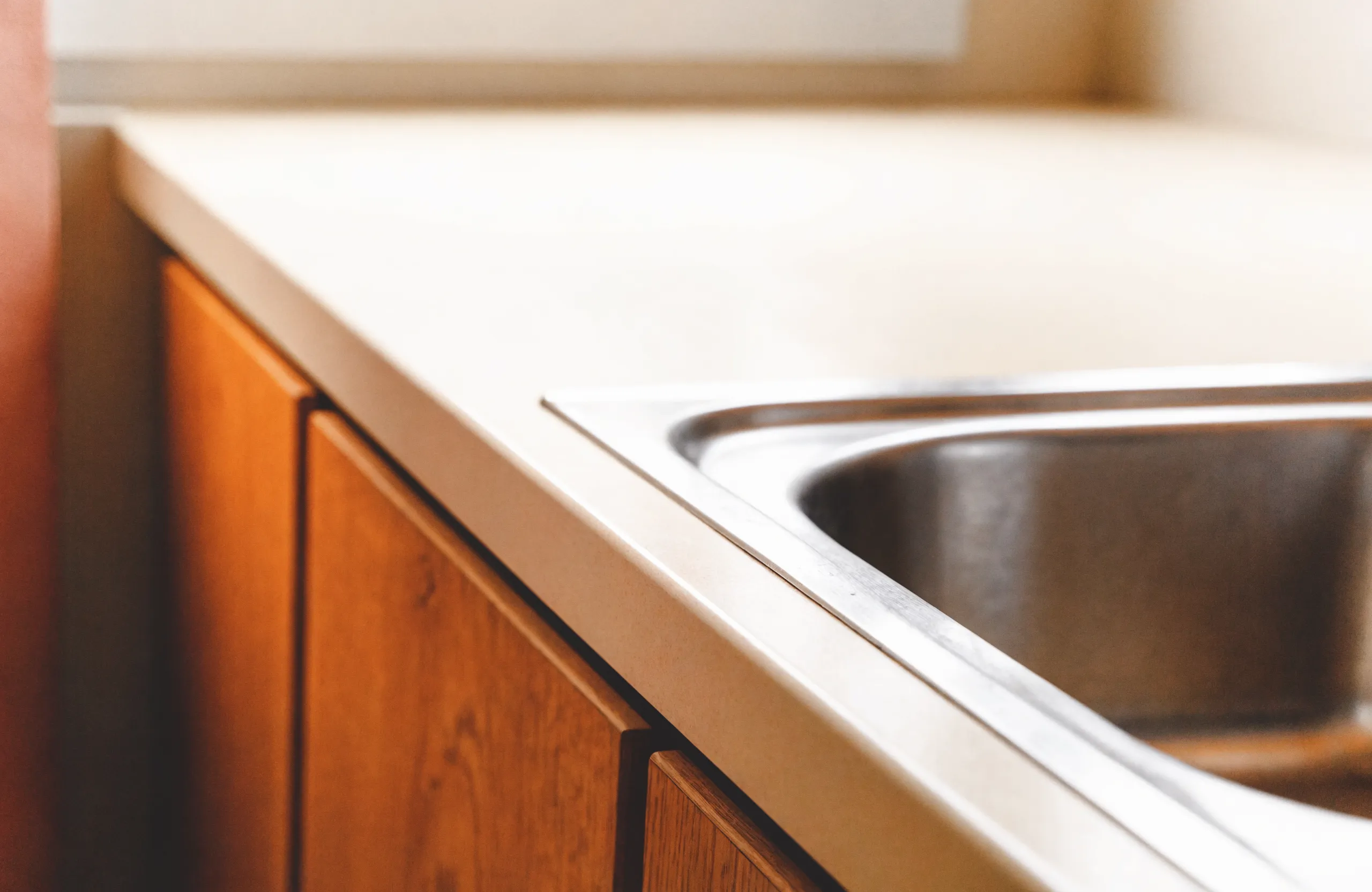 The joint where the old laminate meets the rim of a drop-in sink, the spot that decides whether a counter can be resurfaced at all