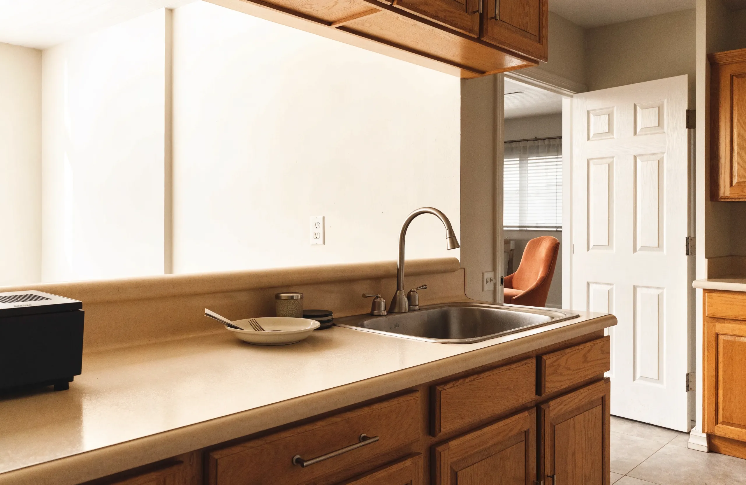 A 1980s Davie kitchen with the original cream laminate counter still in place and the cabinets sound underneath