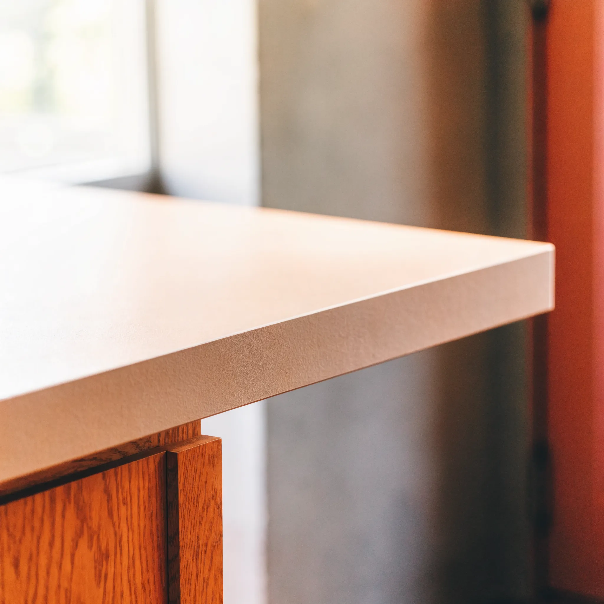 A fresh laminate sheet being rolled down onto an existing countertop deck