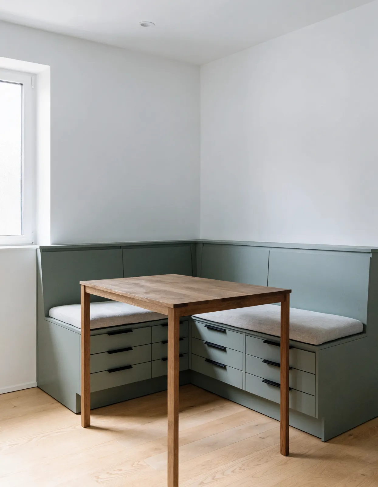 Custom built-ins Davie, FL: a corner banquette built into the wall with drawers under the seat and a table pulled up to it