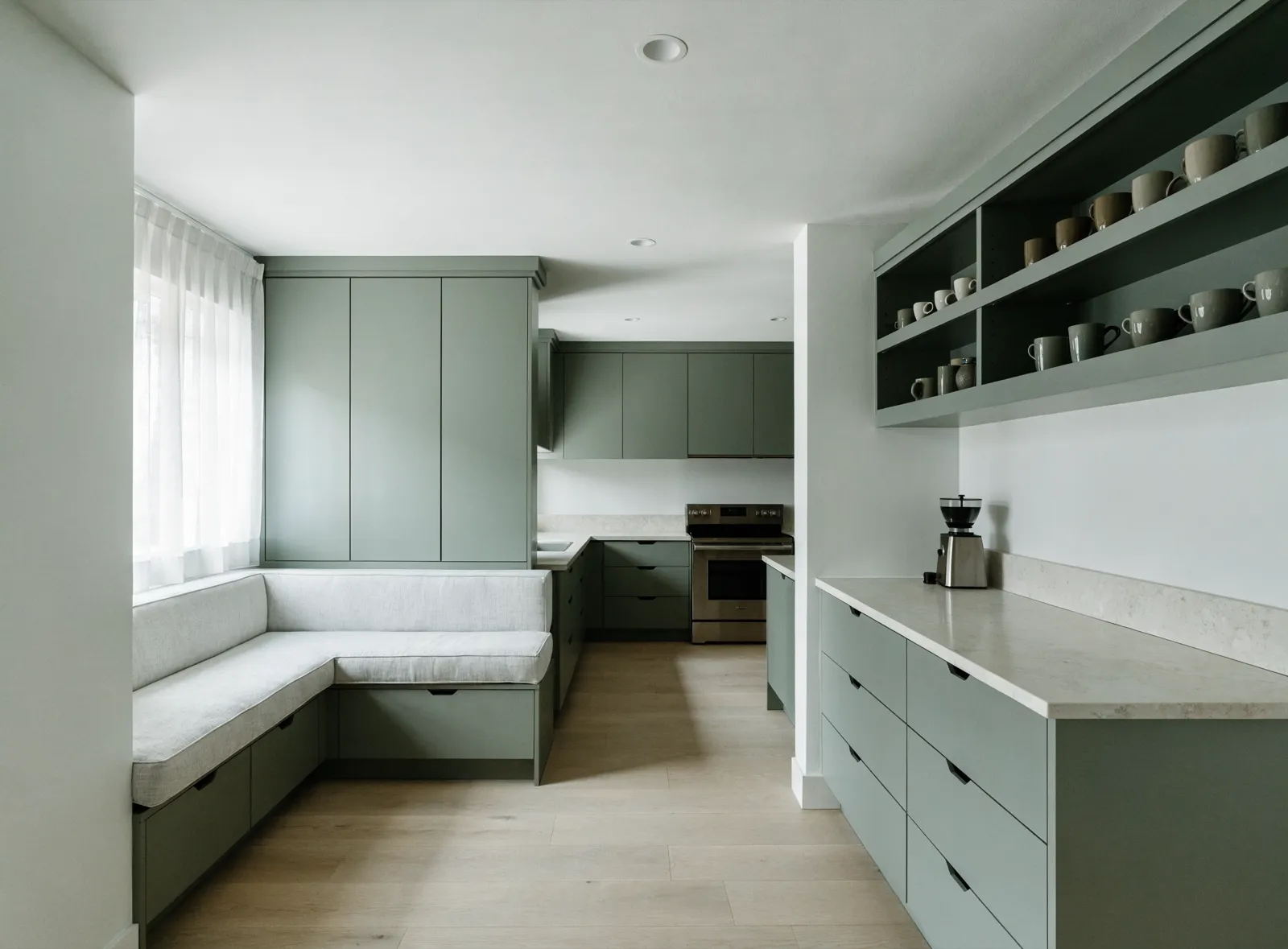 A finished built-in banquette and coffee bar in a Davie kitchen, painted to match the existing cabinets, with the window and the range beyond it