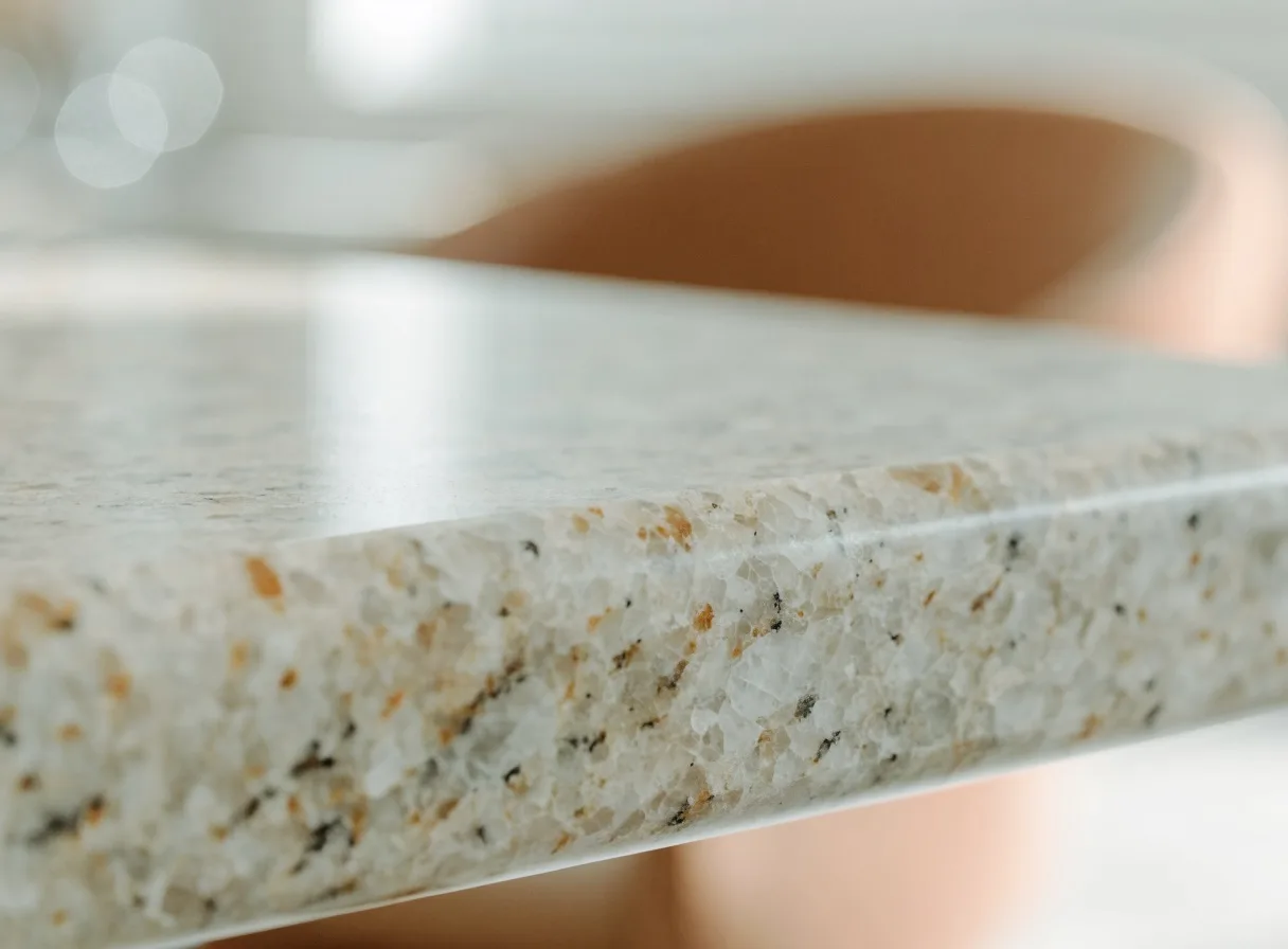 Granite countertop installation in Davie, FL: the eased edge of a cream granite slab, the crystalline grain of the quarried stone visible along the profile