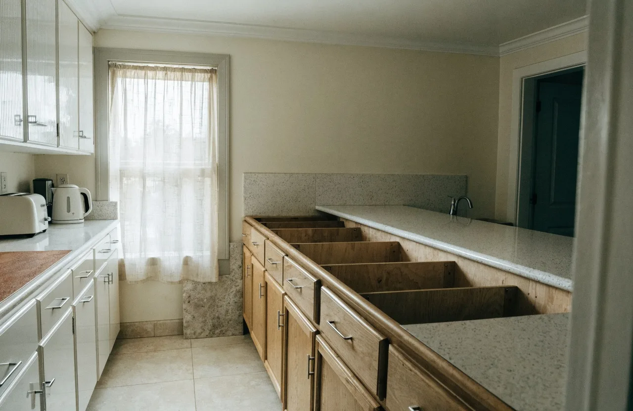 A 1980s Davie kitchen with the original laminate counter still on one run and the cabinet boxes cleared for a new stone top