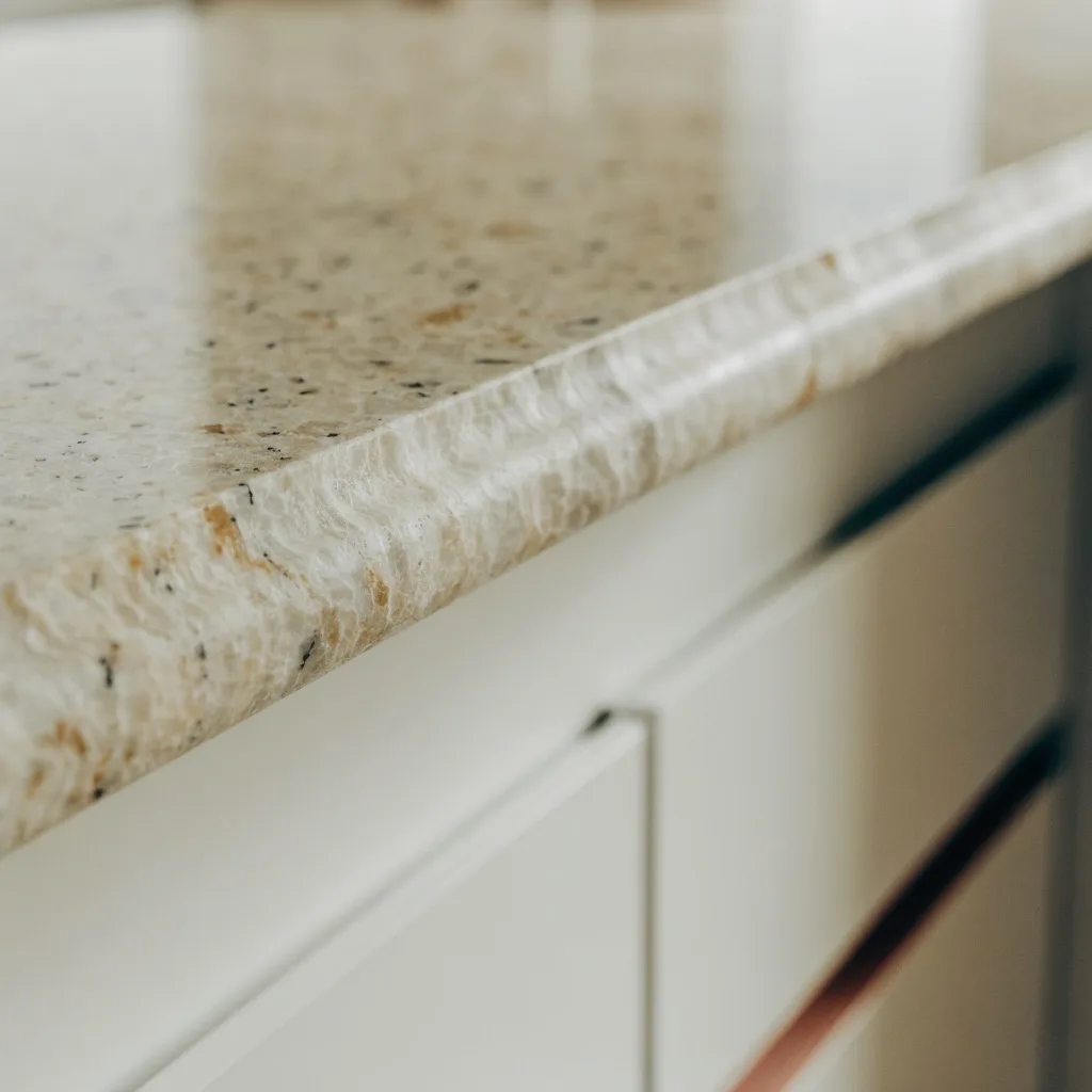 Honed granite with a flat matte surface next to the rim of a stainless undermount sink