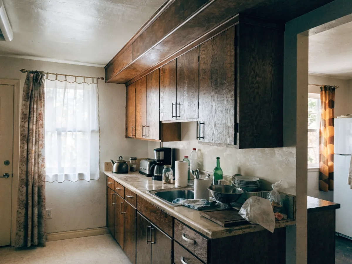 Kitchen remodeling near Bergeron Rodeo Grounds in Davie: an original 1970s kitchen with dark wood fronts, a laminate counter and a closed soffit over the wall cabinets
