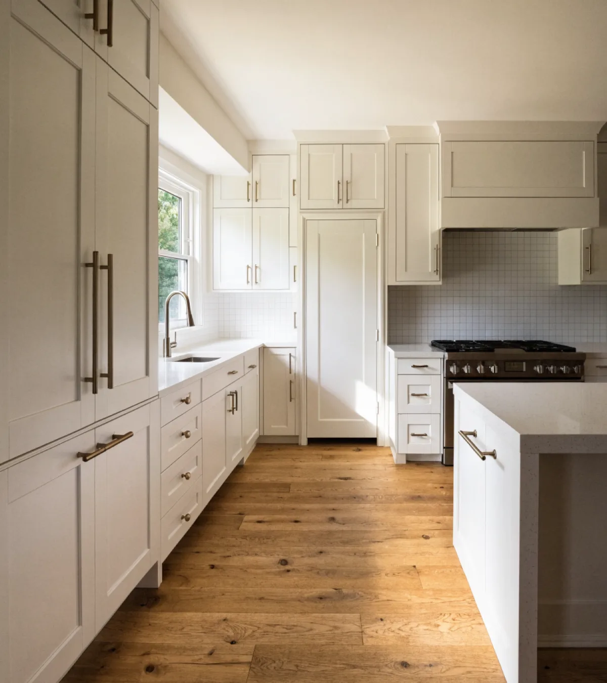 Kitchen remodeling near Flamingo Gardens in Davie: a finished kitchen in a large single family house, painted cabinets running past a center island to a tall pantry wall