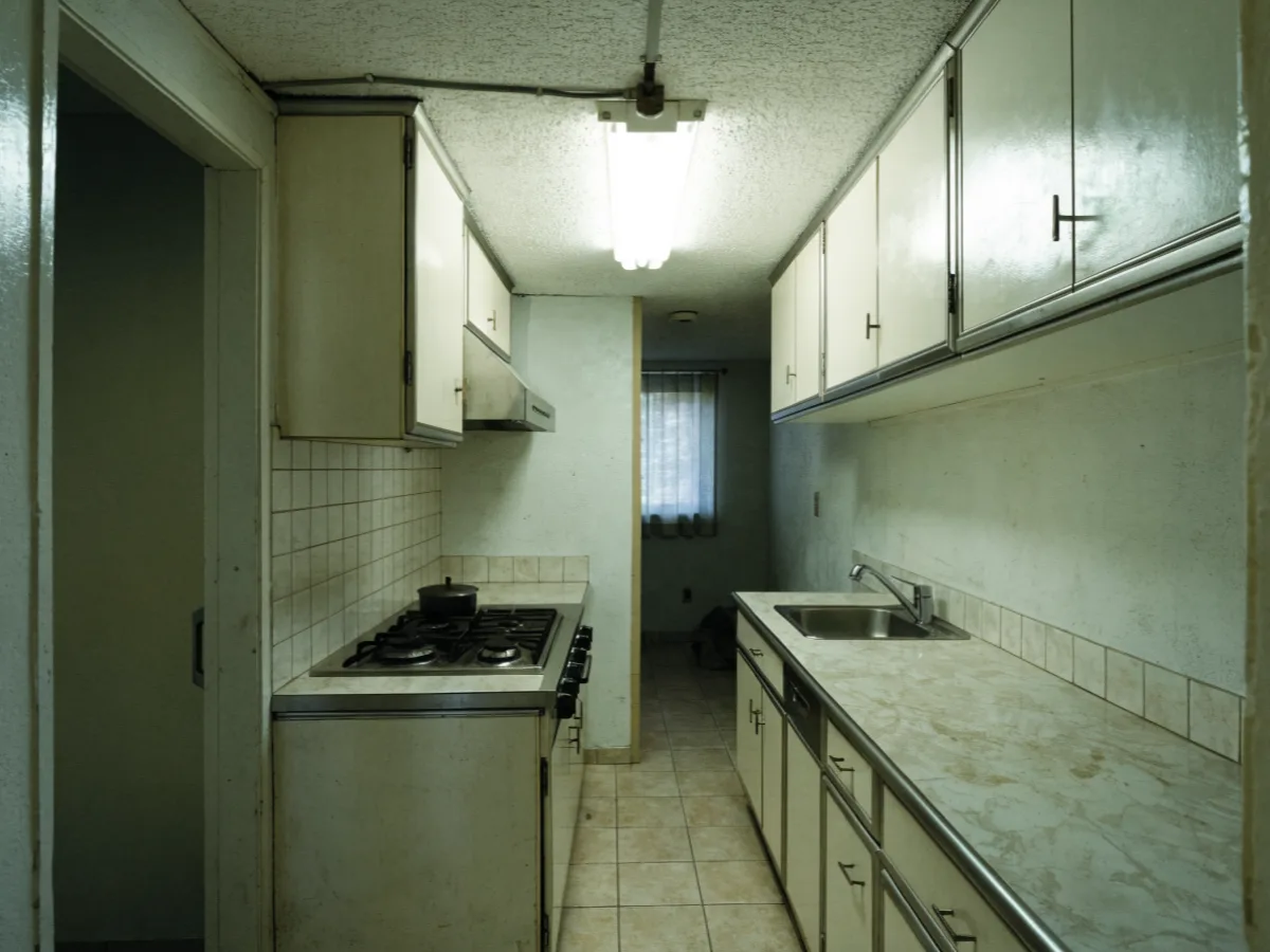 Kitchen remodeling near Nova Southeastern University in Davie: an original condominium kitchen with a closed galley run, laminate counters and a soffit over the wall cabinets