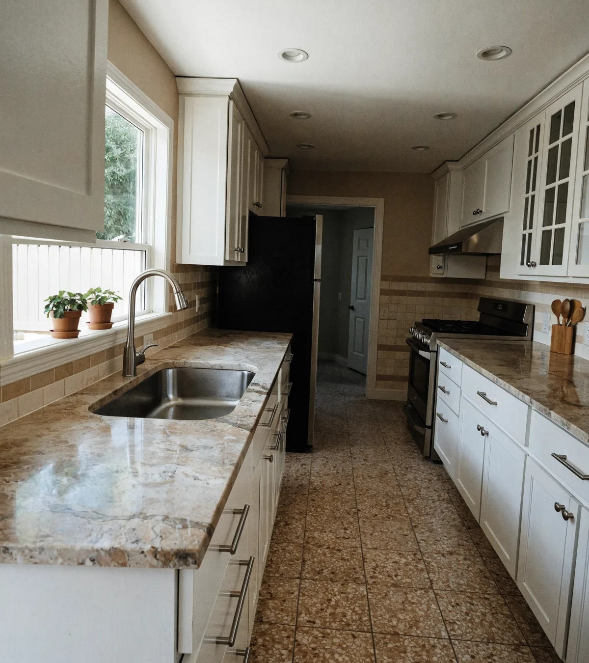Kitchen remodeling near Pine Island Ridge in Davie: a finished kitchen with painted shaker cabinets and a stone counter in a 1980s single story house
