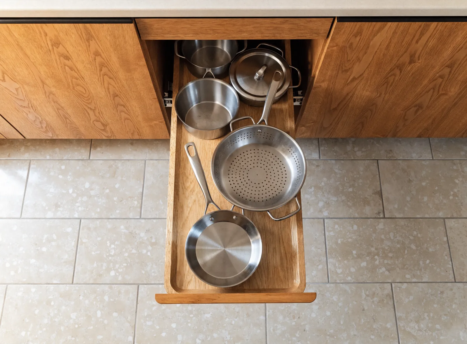 Kitchen storage solutions in Davie, FL: one pull-out tray drawn fully clear of a base cabinet, the pots inside read from above instead of from the front