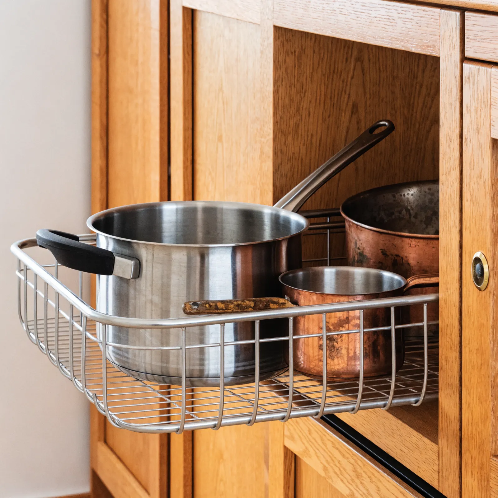 A swing-out blind corner unit half deployed, the front tray pivoted clear of the opening and the rear tray following it forward out of the dead space