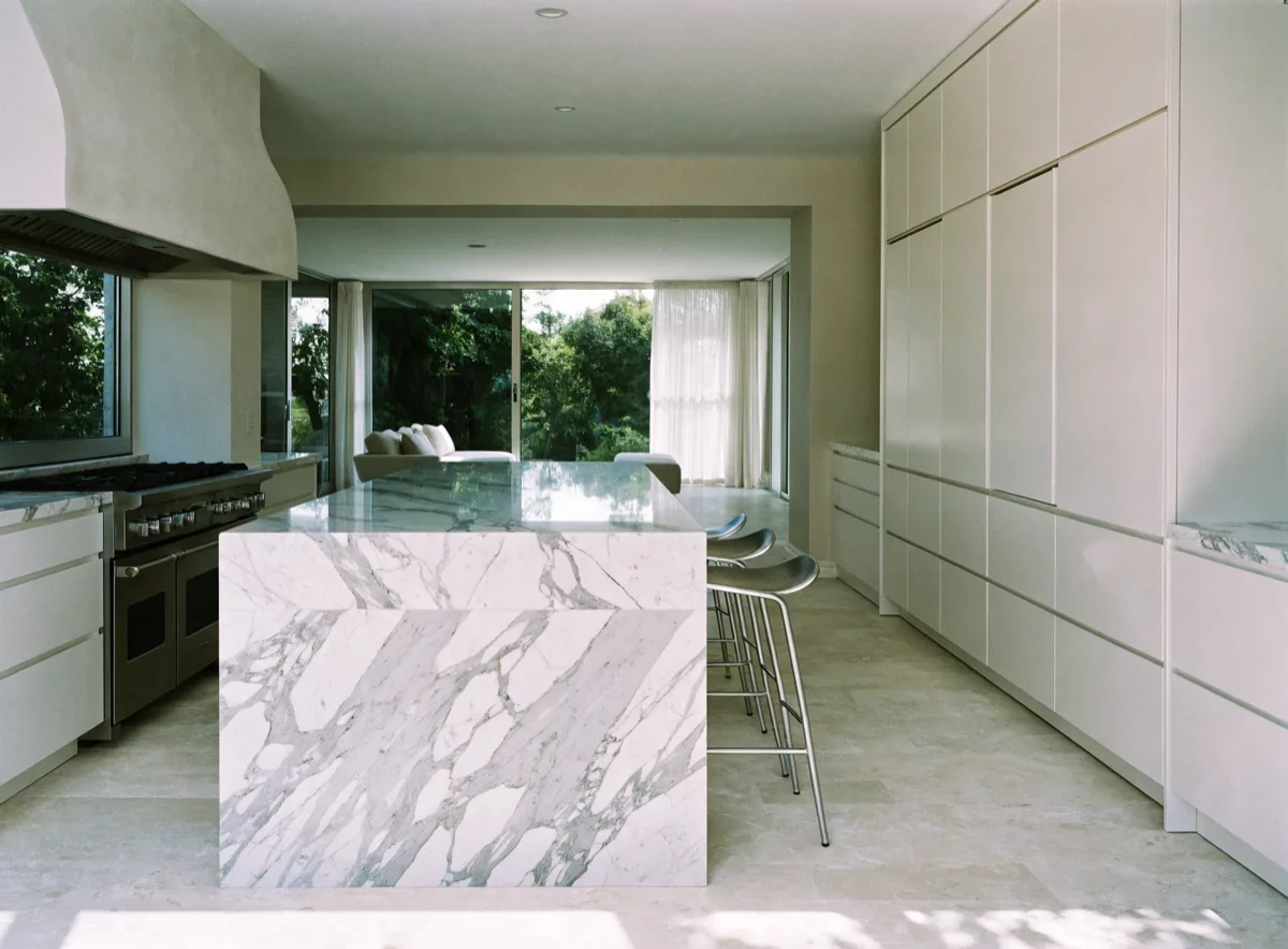 Kitchen opened to the living room in Davie, FL, with a seated island and a run of integrated cabinets