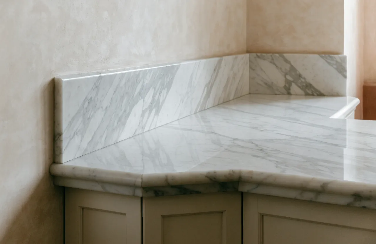 A marble run carried around an inside corner onto the second wall with the veining matched across the seam