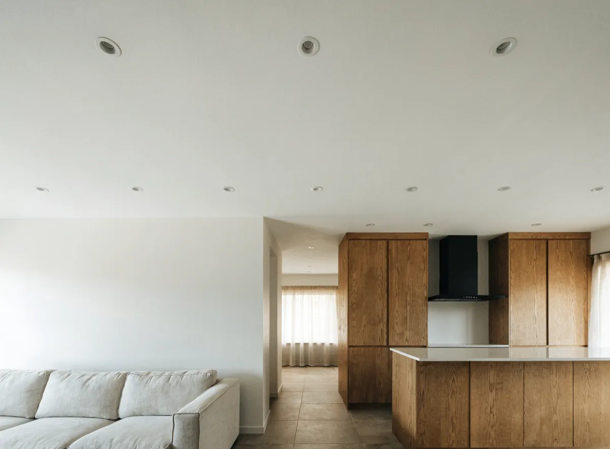The ceiling of an opened Davie kitchen where the dividing wall stood, one flat plane with a line of recessed lights and no bulkhead