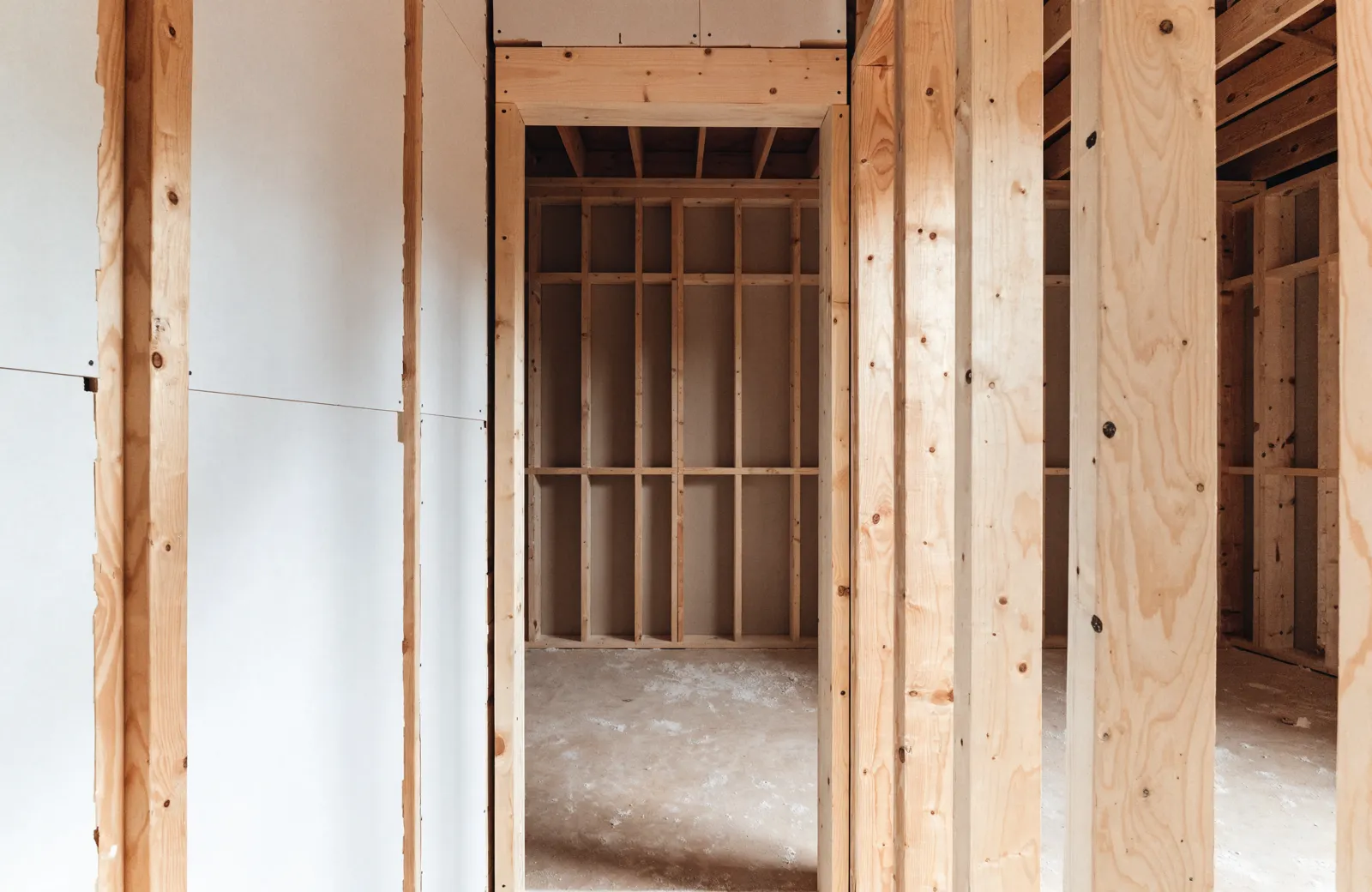 A framed walk-in pantry doorway under construction, studs and drywall around the opening, the job this page is not