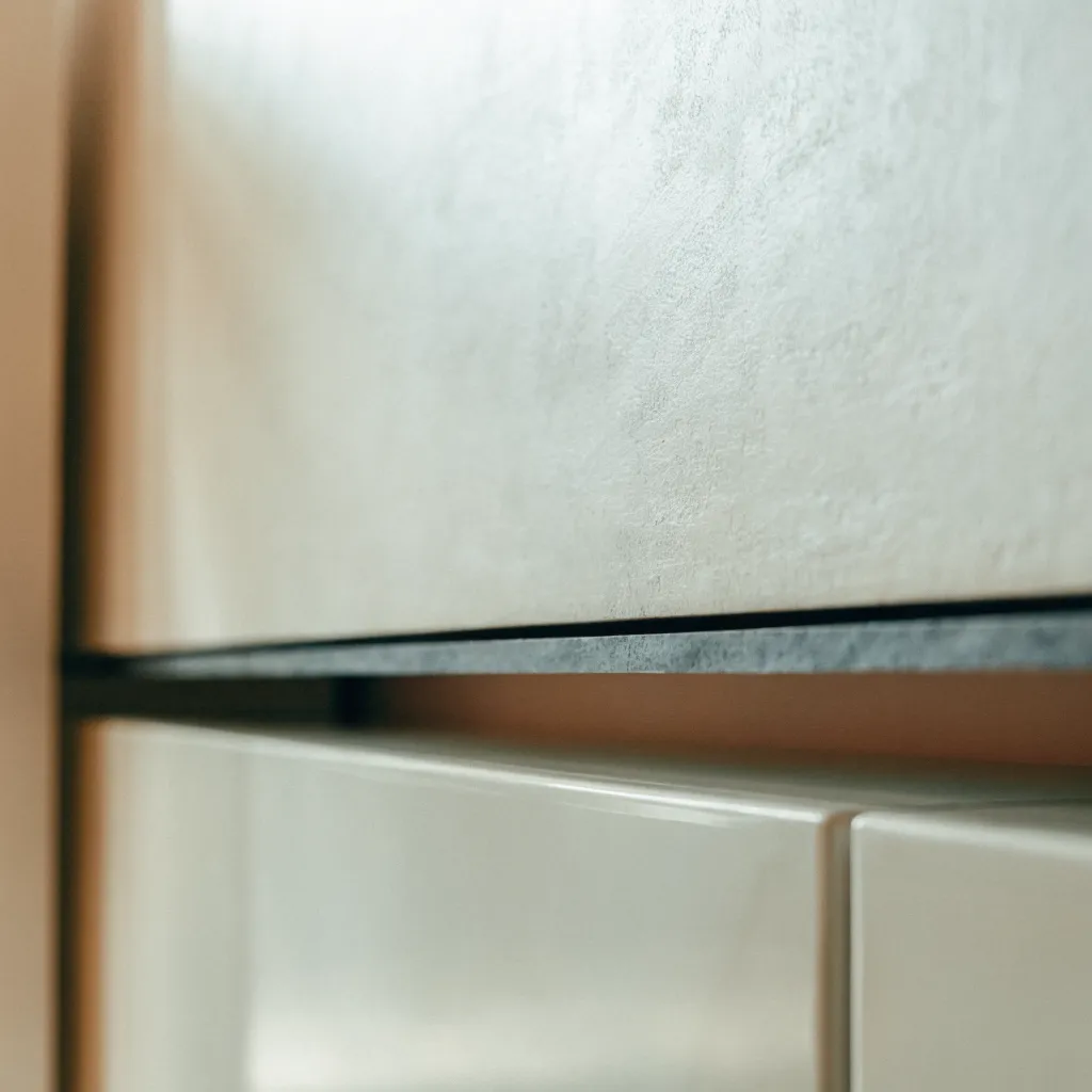 The 6 mm edge of a porcelain panel, a thin dark line where the slab meets the cabinet front below