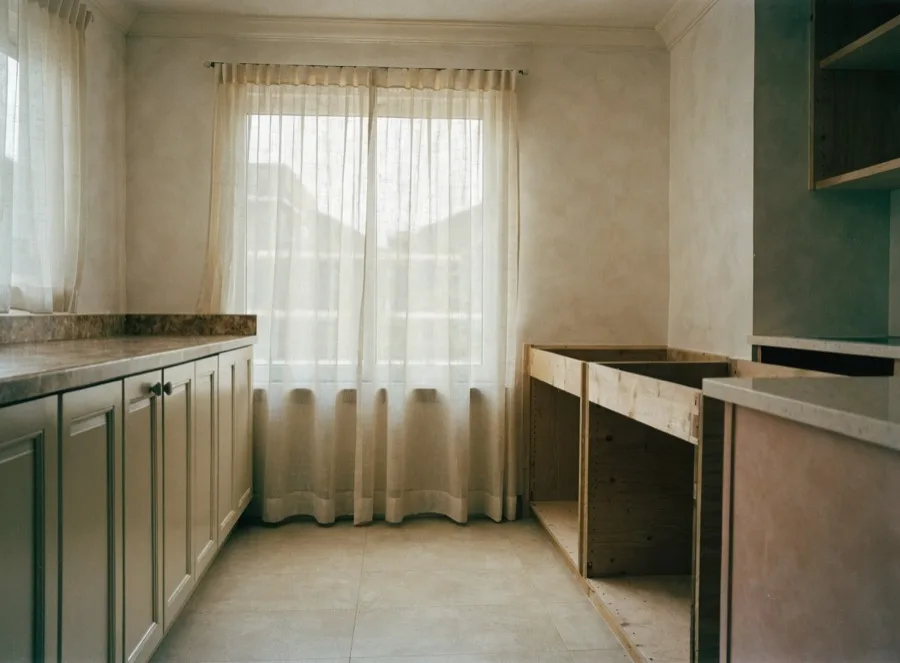 A 1980s Davie kitchen with the original counter still on one run and the cabinet boxes cleared for a new quartz top