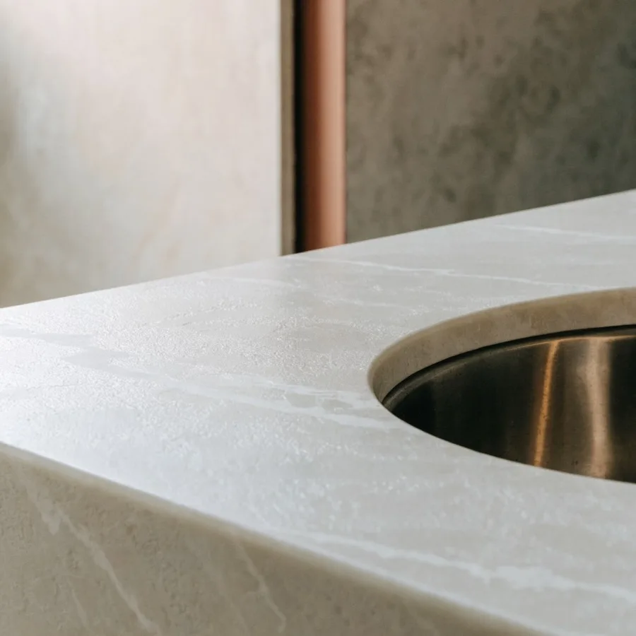 Honed quartz with a flat matte surface next to a stainless undermount sink