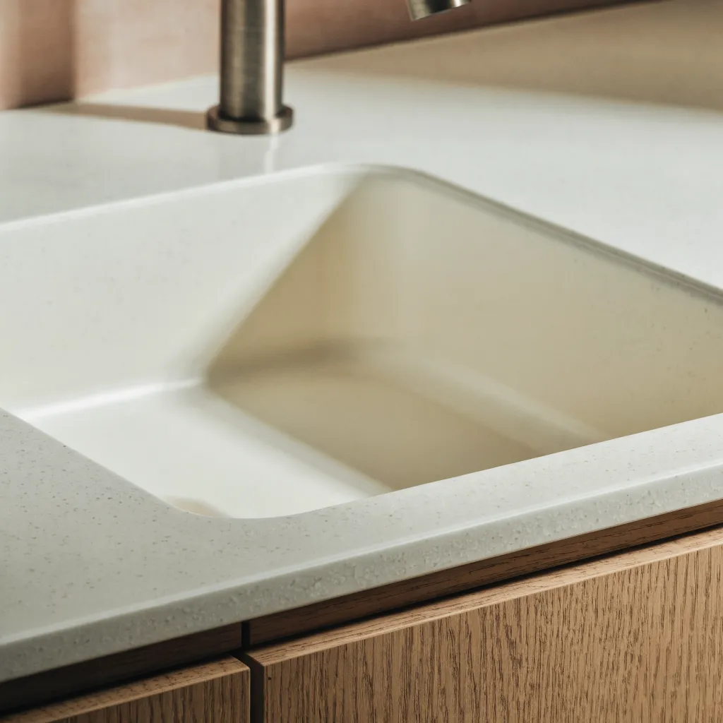 An integrated solid surface bowl bonded under the counter, the two pieces reading as one with no rim and no caulk line